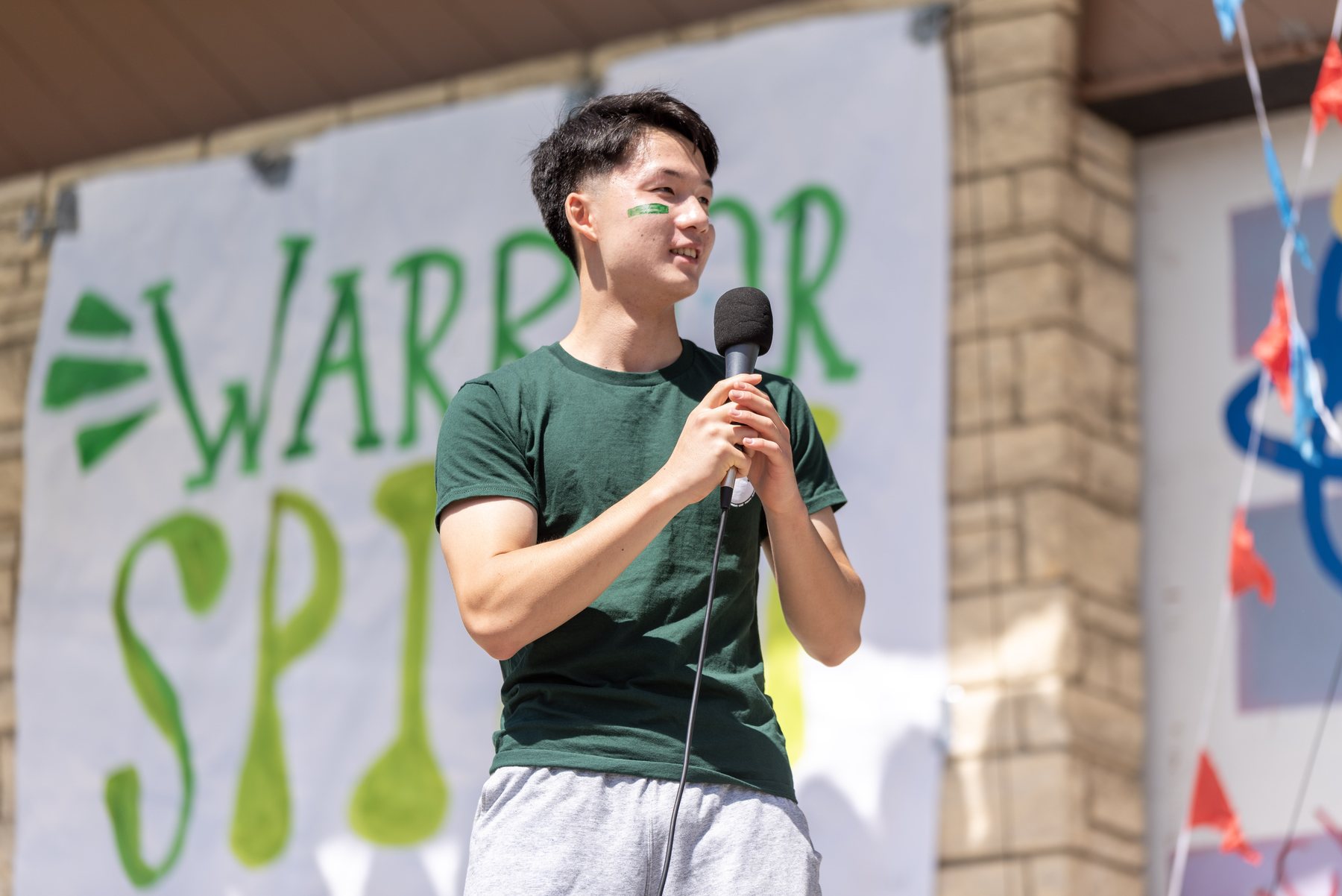 Jadon running the Green & White Assembly with a microphone