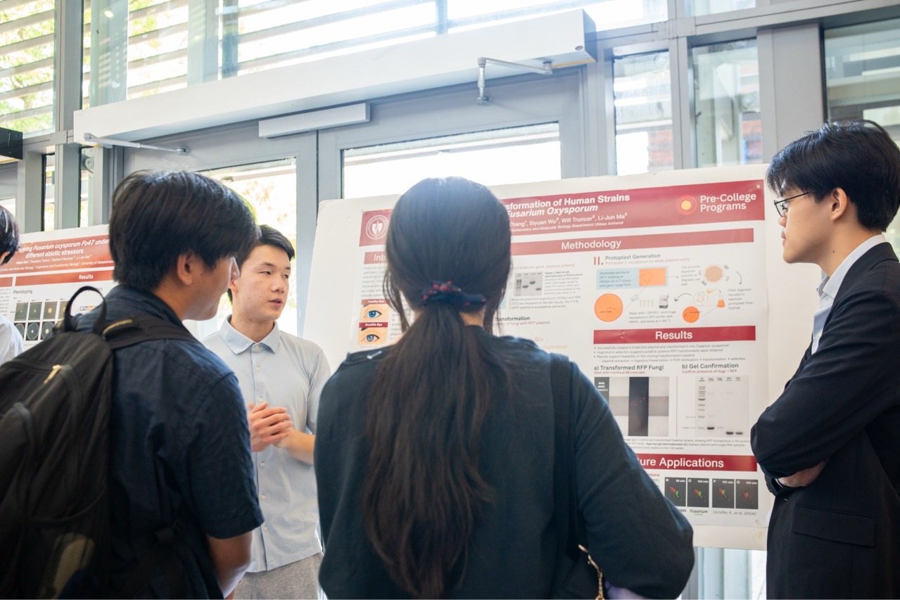 Jadon walking a visitor through the RFP poster during the poster session